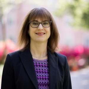 Juvenile Law Attorney Deana Fleming smiles for a headshot in the UNC Garden in Chapel Hill.